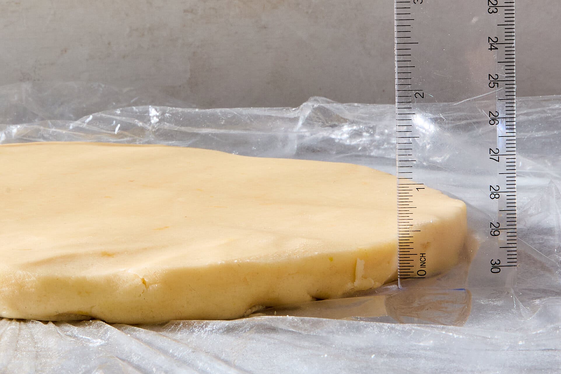 A side image of a slab of dough and a ruler measuring its thickness.